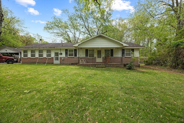 ranch-style house featuring covered porch, a front lawn, and brick siding