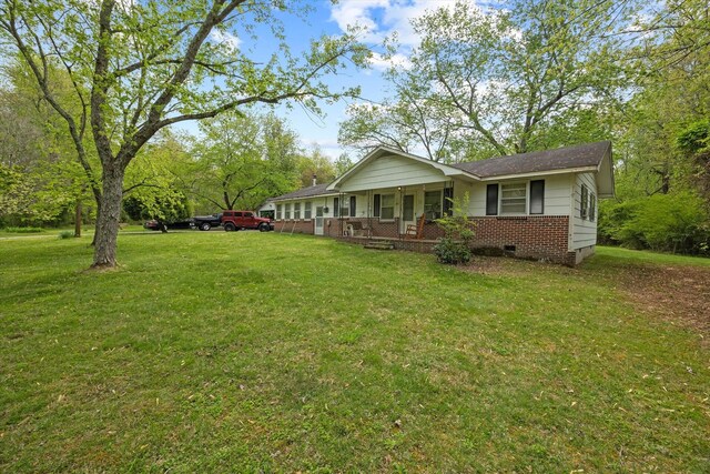 view of front of property with covered porch, crawl space, brick siding, and a front lawn