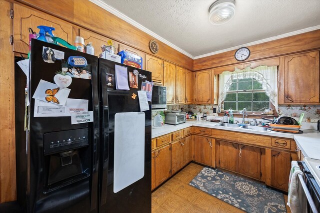 kitchen with black fridge with ice dispenser, crown molding, light countertops, a textured ceiling, and a sink