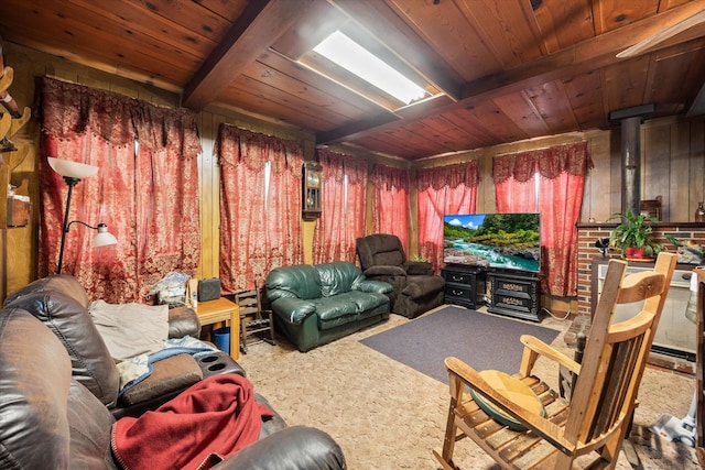 living room with wood ceiling, beamed ceiling, a wood stove, and carpet floors