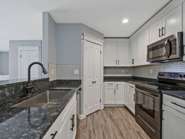 3120 Trenton Rd, Clarksville, TN 37040 - kitchen with stainless steel appliances, white cabinetry, a sink, and light wood-style flooring