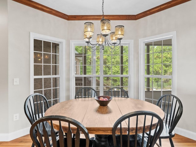 dining room with crown molding, baseboards, a healthy amount of sunlight, and a notable chandelier