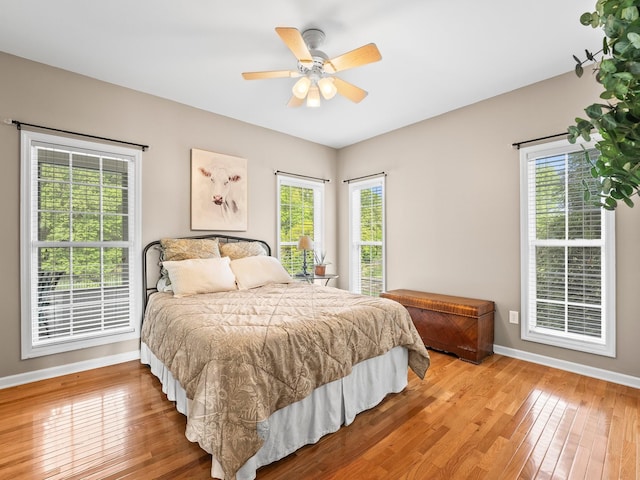 bedroom with baseboards, ceiling fan, and hardwood / wood-style flooring