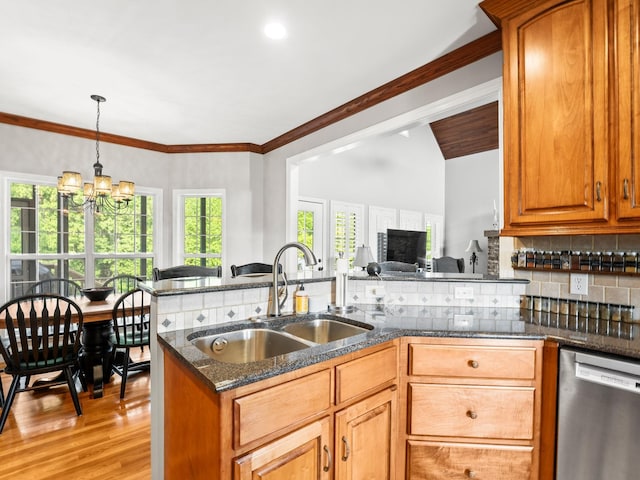 kitchen featuring tasteful backsplash, stainless steel dishwasher, light wood-type flooring, a sink, and dark stone countertops