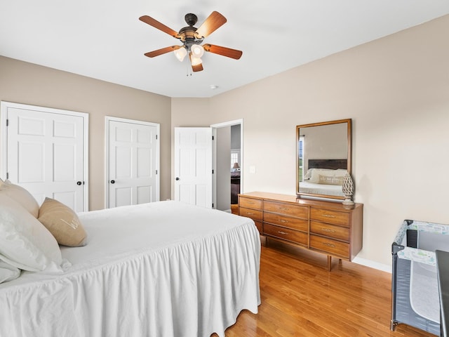 bedroom with a ceiling fan, baseboards, and light wood-style floors