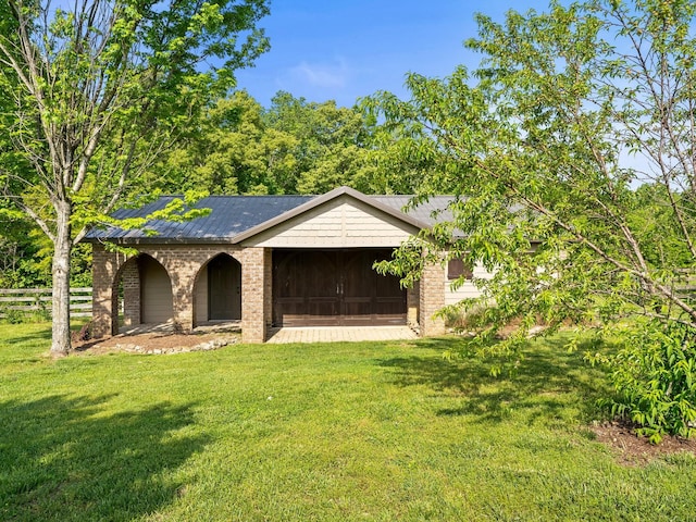 ranch-style home with brick siding, fence, and a front lawn