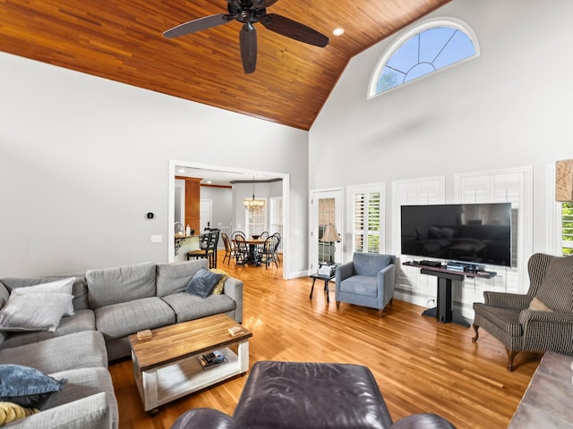 living area featuring high vaulted ceiling, wooden ceiling, wood finished floors, and ceiling fan with notable chandelier
