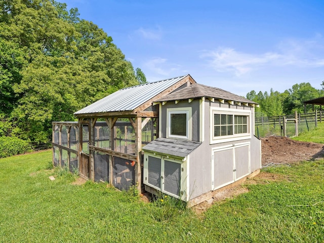 view of poultry coop featuring a lawn and fence