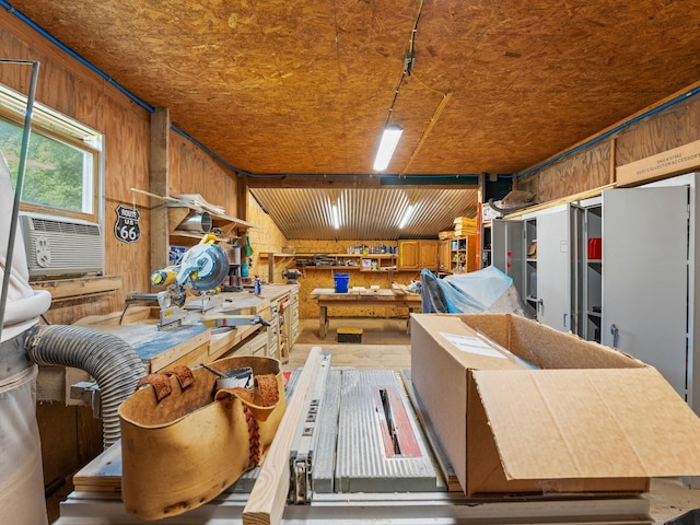 miscellaneous room featuring a workshop area, cooling unit, and wood walls