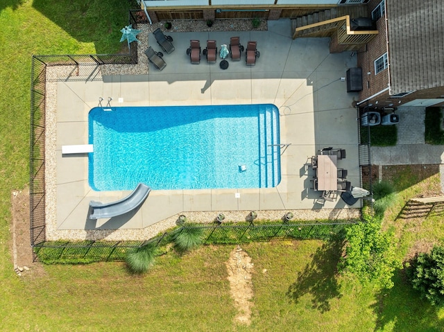 view of swimming pool with a yard and a diving board