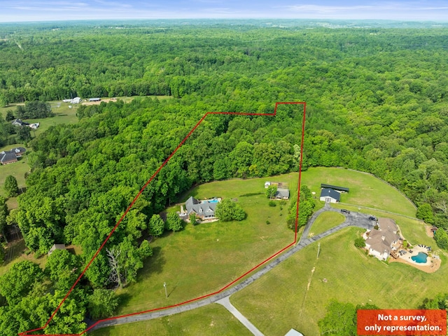 drone / aerial view featuring a wooded view