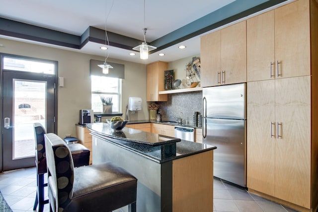 3000 Vanderbilt Pl Unit 118, Nashville, TN 37212 - kitchen featuring light brown cabinetry, light tile patterned flooring, dark stone countertops, stainless steel appliances, and tasteful backsplash