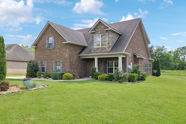 craftsman inspired home featuring brick siding, a front lawn, and roof with shingles