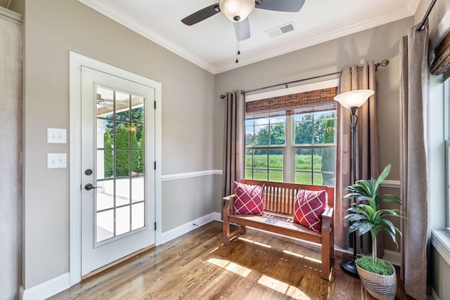 entryway with a ceiling fan, visible vents, light wood-type flooring, baseboards, and ornamental molding