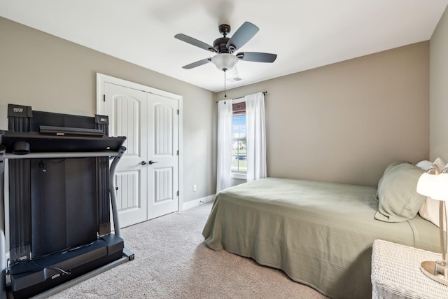 bedroom with carpet floors, visible vents, a closet, baseboards, and a ceiling fan