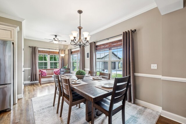 dining room featuring an inviting chandelier, ornamental molding, baseboards, and wood finished floors