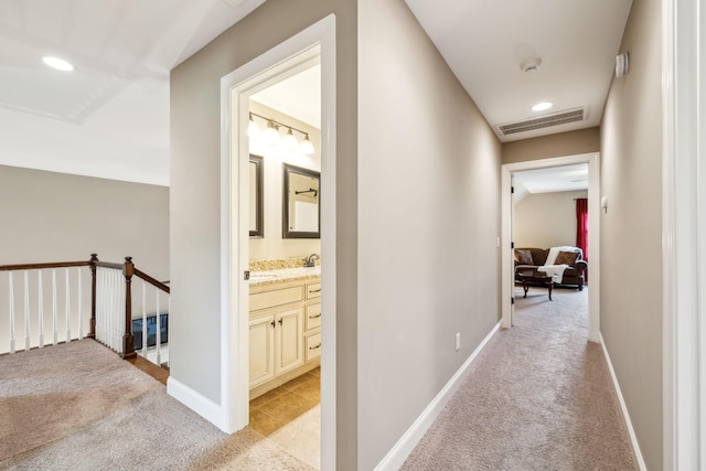 hallway featuring visible vents, light colored carpet, baseboards, an upstairs landing, and recessed lighting