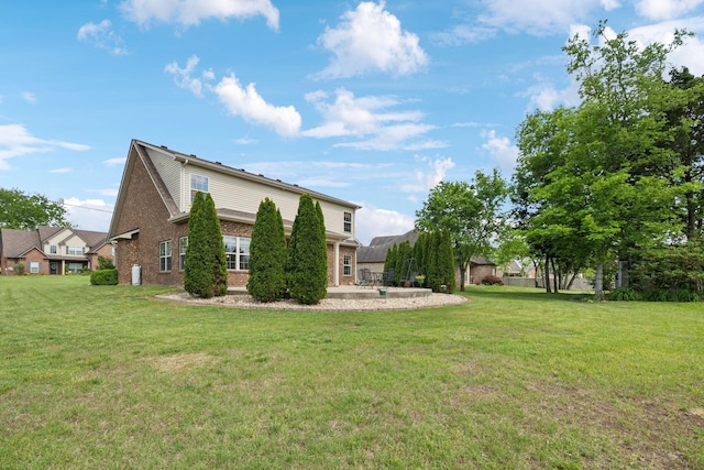 view of property exterior featuring brick siding, a yard, and a patio
