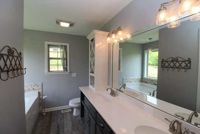 full bathroom featuring visible vents, a sink, a garden tub, and wood finished floors