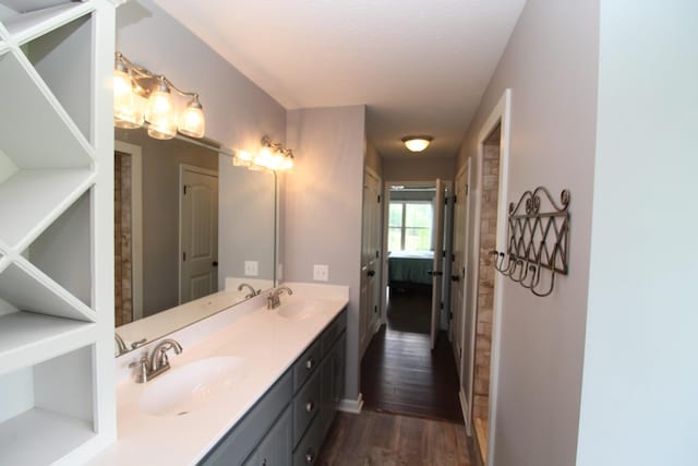 full bath with a sink, ensuite bathroom, double vanity, and wood finished floors