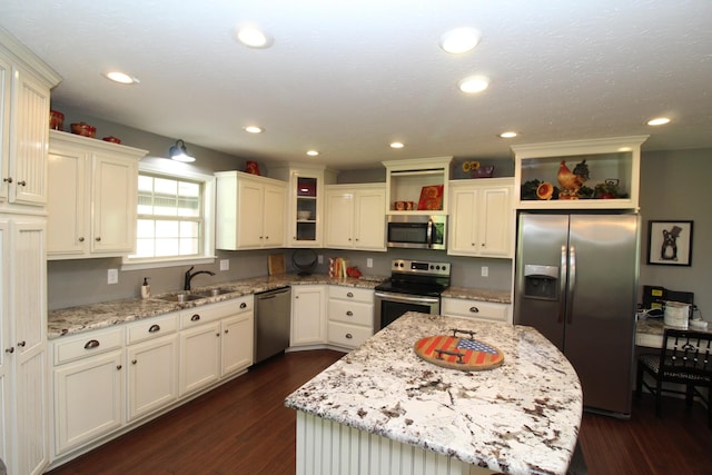 kitchen featuring dark wood-type flooring, a sink, open shelves, and appliances with stainless steel finishes