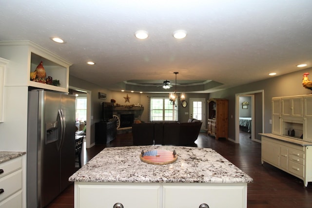 kitchen with a fireplace, open floor plan, a center island, stainless steel fridge with ice dispenser, and a ceiling fan