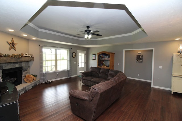 living room featuring ornamental molding, a tray ceiling, ceiling fan, and wood finished floors