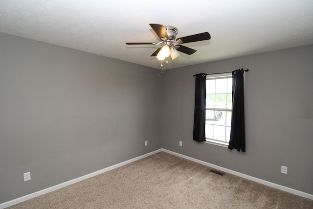 carpeted empty room featuring a ceiling fan, baseboards, and visible vents