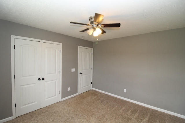 unfurnished bedroom with a closet, baseboards, ceiling fan, and light carpet