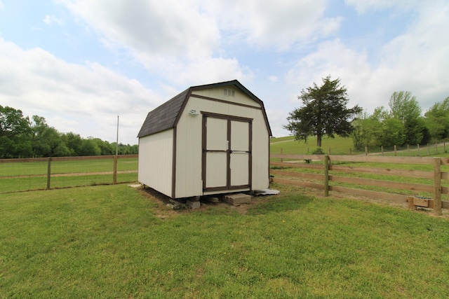 view of shed with fence and a rural view