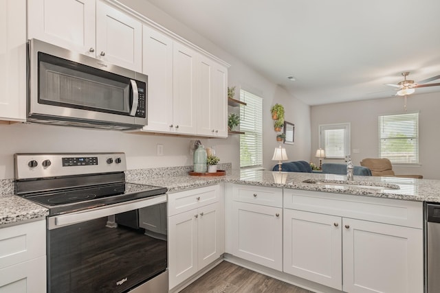 kitchen featuring ceiling fan, white cabinetry, a sink, light wood-style flooring, and appliances with stainless steel finishes