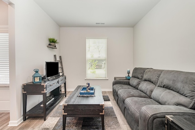 living room with baseboards, wood finished floors, and visible vents