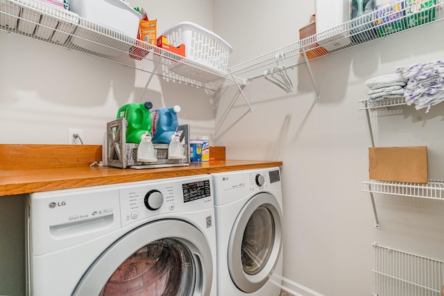 clothes washing area featuring laundry area, washer and clothes dryer, and baseboards