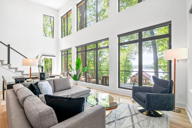 living area featuring stairway, a water view, and a wealth of natural light