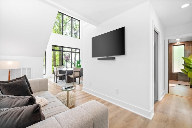 living area with baseboards, visible vents, a wealth of natural light, and light wood finished floors