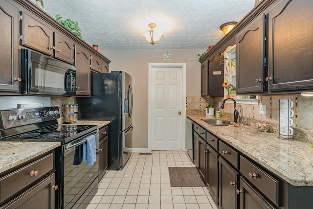 kitchen featuring decorative backsplash, dark brown cabinets, a sink, light tile patterned floors, and black appliances