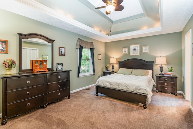 bedroom with carpet floors, baseboards, and a tray ceiling