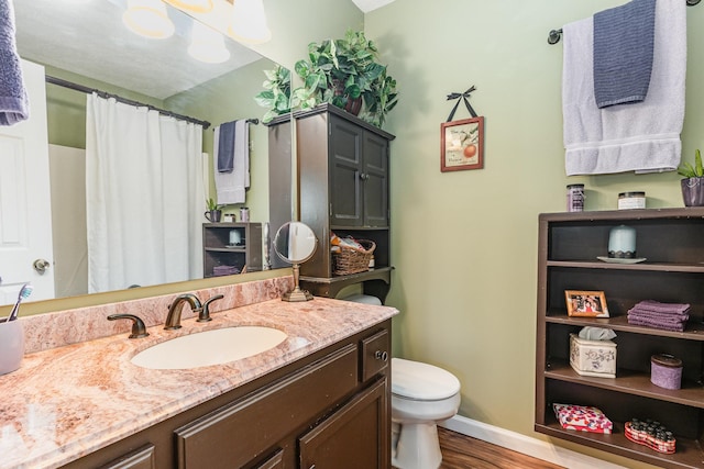 bathroom with wood finished floors, vanity, baseboards, toilet, and a shower with shower curtain