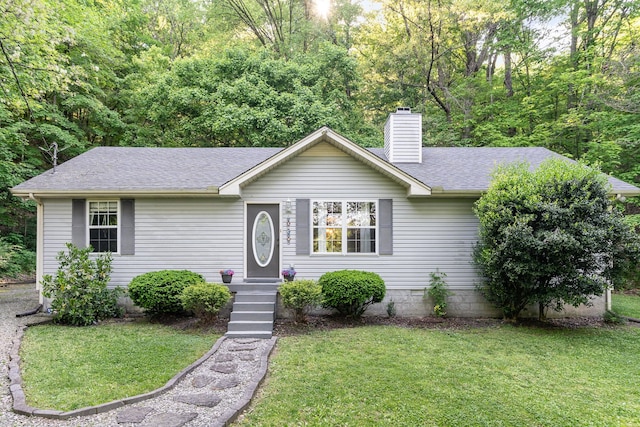 ranch-style home with a shingled roof, a front lawn, and a chimney