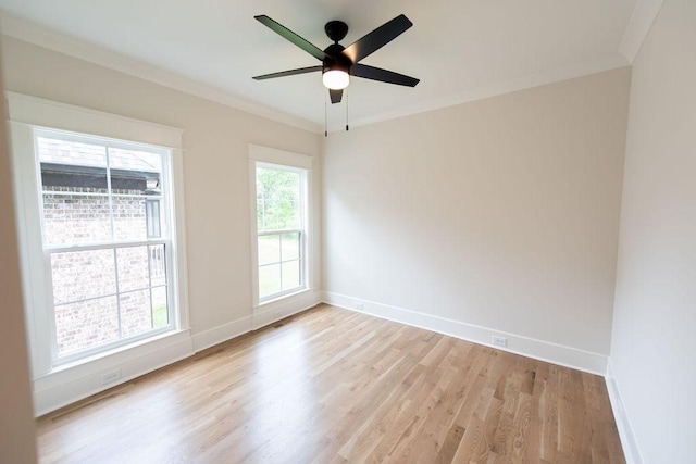 empty room featuring crown molding, baseboards, a ceiling fan, and light wood-style flooring