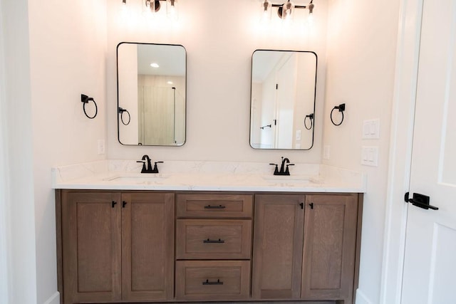 full bath with double vanity, baseboards, and a sink