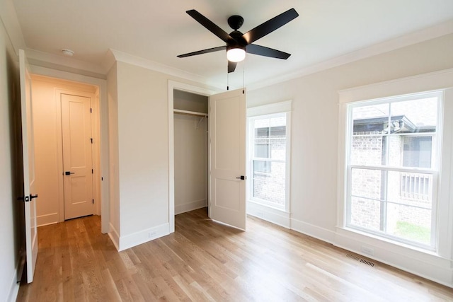 unfurnished bedroom featuring crown molding, visible vents, multiple windows, and light wood finished floors