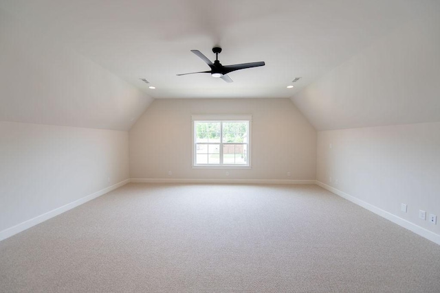 additional living space featuring baseboards, lofted ceiling, and light carpet