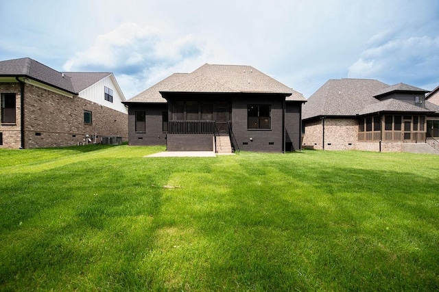 back of property with a yard, crawl space, and a sunroom