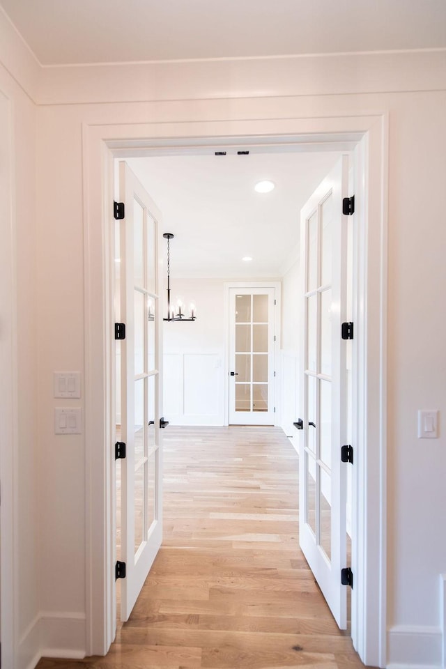 hall with french doors, recessed lighting, light wood finished floors, and a chandelier