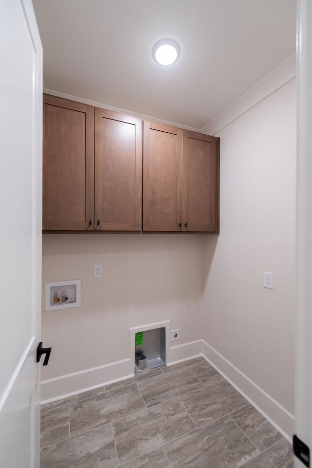 laundry room featuring electric dryer hookup, hookup for a washing machine, cabinet space, and baseboards