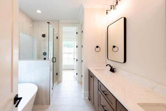 bathroom with double vanity, a freestanding tub, a shower stall, and a sink
