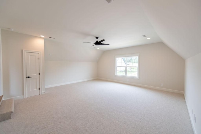 additional living space with a ceiling fan, baseboards, light carpet, and vaulted ceiling