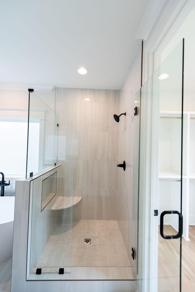 bathroom with a freestanding bath, a stall shower, and recessed lighting