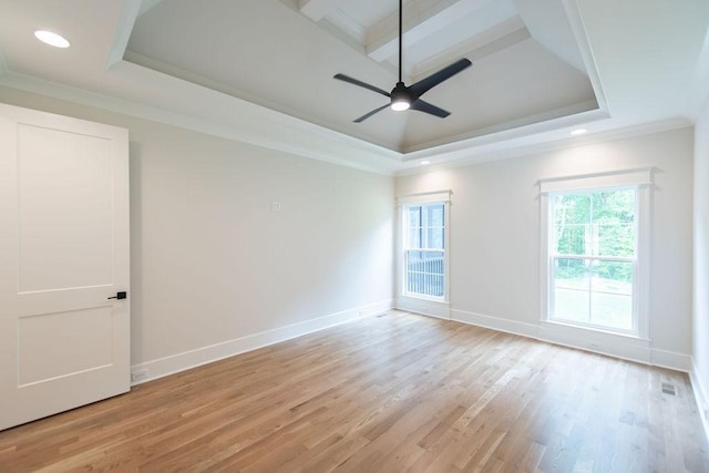 unfurnished room with a tray ceiling, ornamental molding, baseboards, and light wood-style floors
